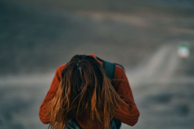 Rear view of woman standing against blurred background