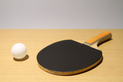 Close-up of table tennis racket and ball on table 