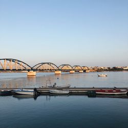 Bridge over river against sky in city