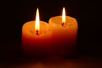 Close-up of lit candles against black background