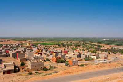 Buildings in city against clear blue sky