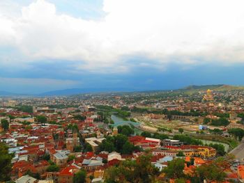 High angle view of cityscape against cloudy sky