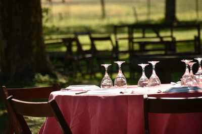 Glasses on tables by chairs at restaurant