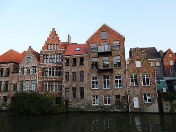 River by buildings against clear sky