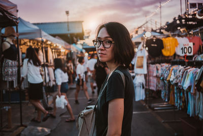 Portrait of young woman standing in city