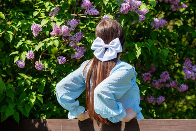 Rear view of woman standing amidst plants