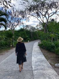 Rear view of woman walking on footpath