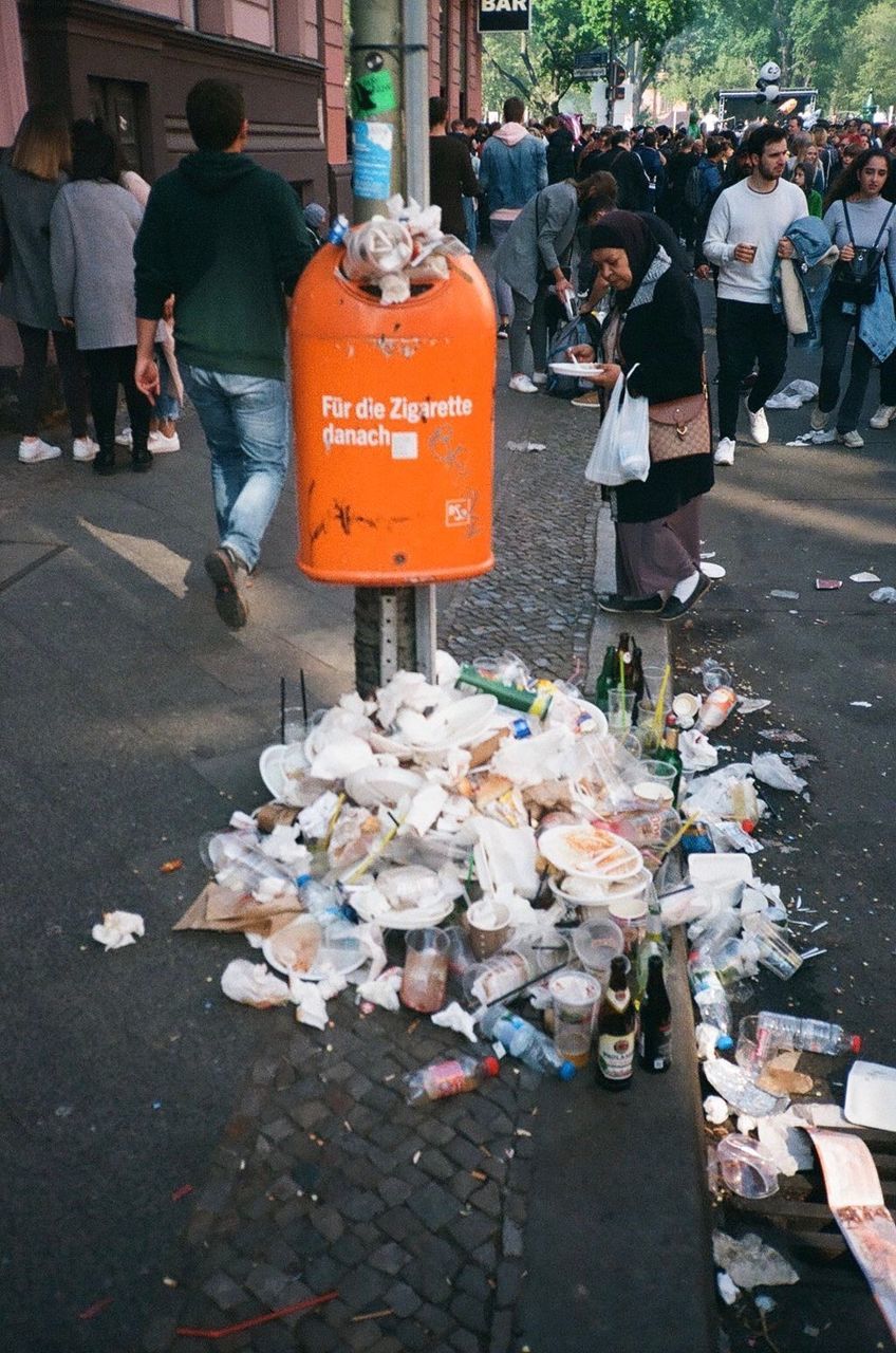 city, street, men, group of people, garbage, real people, incidental people, text, people, communication, day, environmental issues, architecture, lifestyles, messy, crowd, environment, abundance, outdoors, script, pollution