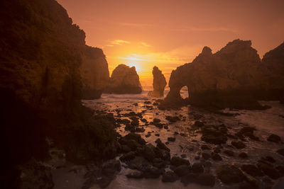 Silhouette of rock formations at seaside