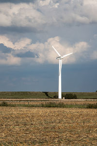 Windmill on field against sky