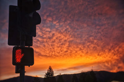 Low angle view of traffic signal against scenic sky