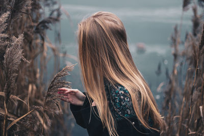 Young woman standing amidst plants