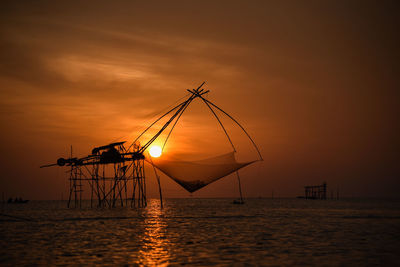 Silhouette sailboat on sea against sky during sunset