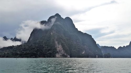 Scenic view of sea and mountains against sky