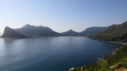 Scenic view of sea and mountains against clear sky