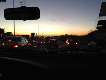 Traffic on road at sunset