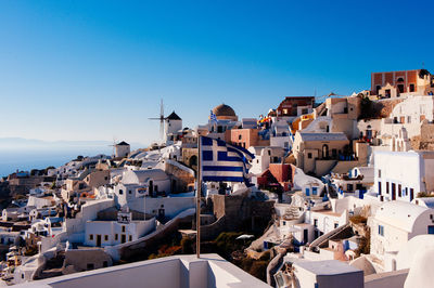 View of buildings in city against clear blue sky