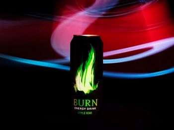 Close-up of illuminated light bulb against black background