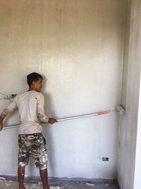 Full length of boy standing against wall at home