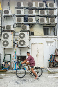 Man working on bicycle against wall