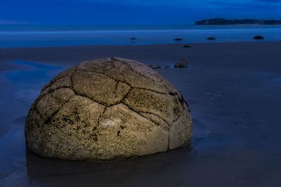 Scenic view of rocks on beach against sky