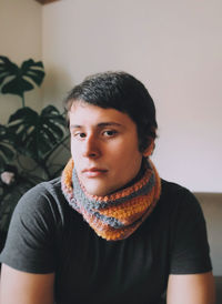 Portrait of young man standing against wall