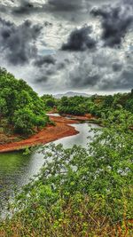 Scenic view of river against cloudy sky