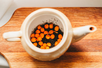 Brewing black tea with sea buckthorn, close-up, top view. diy tea.