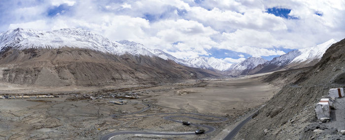 Panorama shot of mountains and blue sky with covered clouds, barren and deserted land in ladakh.