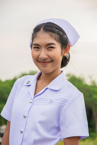 Smiling young nurse on field