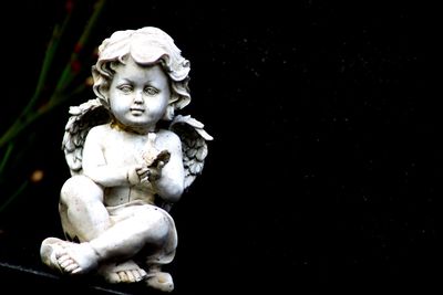 Close-up of statue against black background