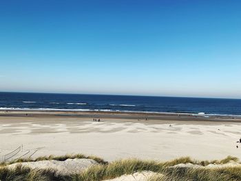 Scenic view of beach against clear blue sky