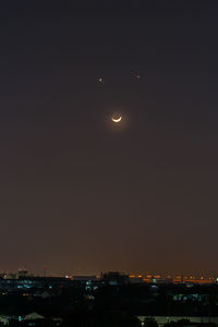 Illuminated cityscape against clear sky at night