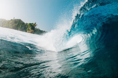 Waves splashing in sea against clear sky