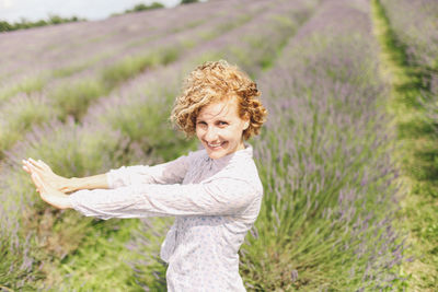 Portrait of happy woman standing on lavender field
