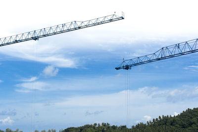 Blue cranes tower in construction area