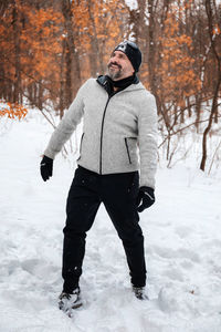 Full length of man standing on snow covered field