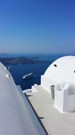 Boats in sea against clear blue sky