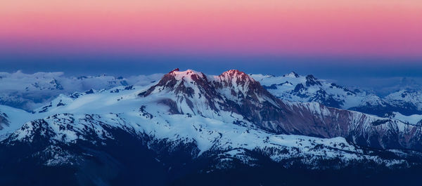 Scenic view of snowcapped mountains against sky during sunset