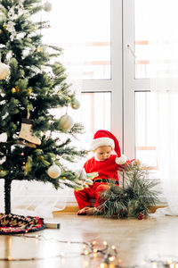 Cute baby under the tree in a new year's costume on christmas eve or new years eve