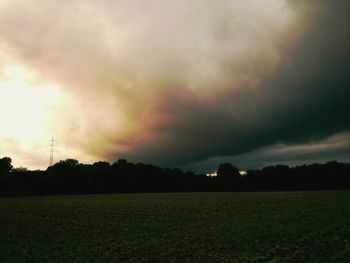 Scenic view of field against cloudy sky