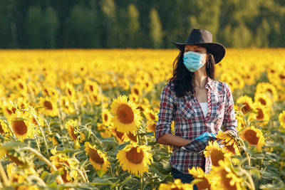 Woman standing in sunflower field