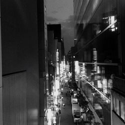 Cars on illuminated street in city at night