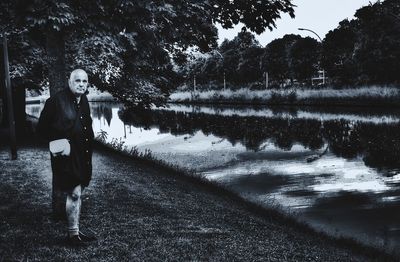Man standing by lake against trees