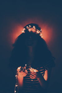 Low angle view of woman standing against sky at night