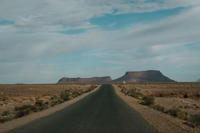 Road amidst desert against sky