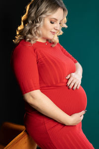 Side view of a woman against red background