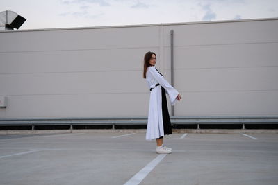 Young woman against sky