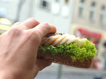 Cropped image of hand holding sandwich