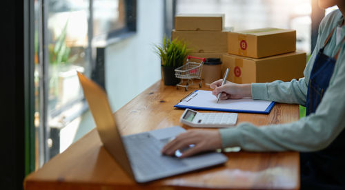 Midsection of businessman working on table